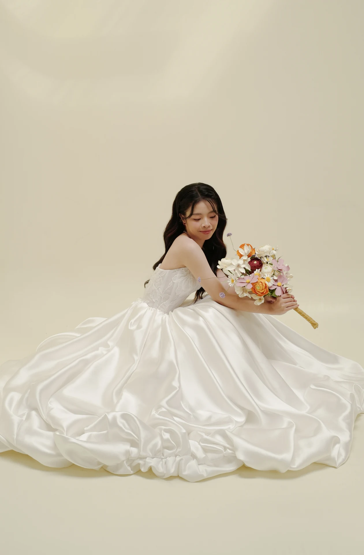 Phương ngồi trong váy cưới, ôm bó hoa
